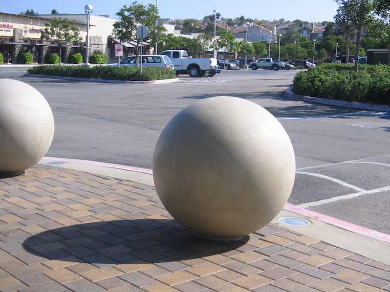 A spherical concrete bollard, helping to protect pedestrians from cars