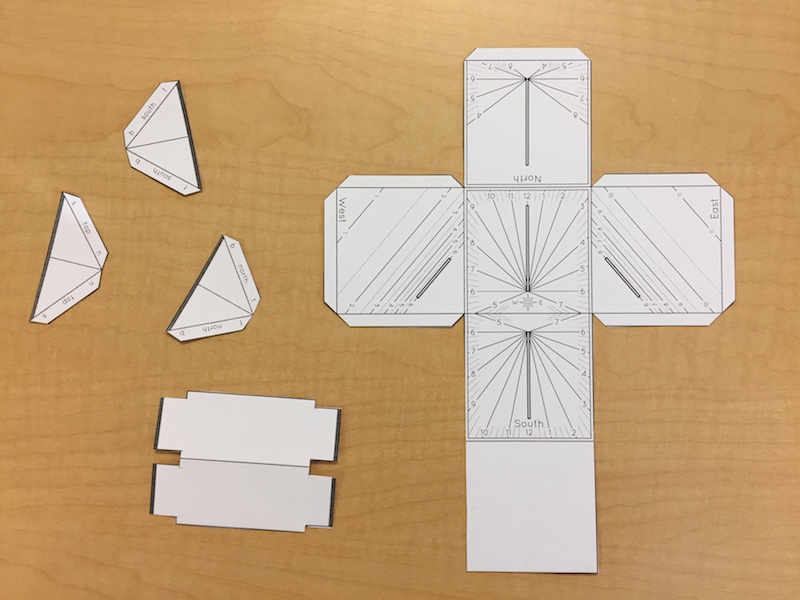 The cut out parts of a paper cube sundial