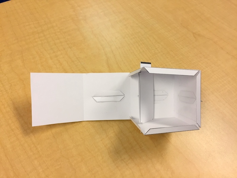 A partially assembled paper cube sundial