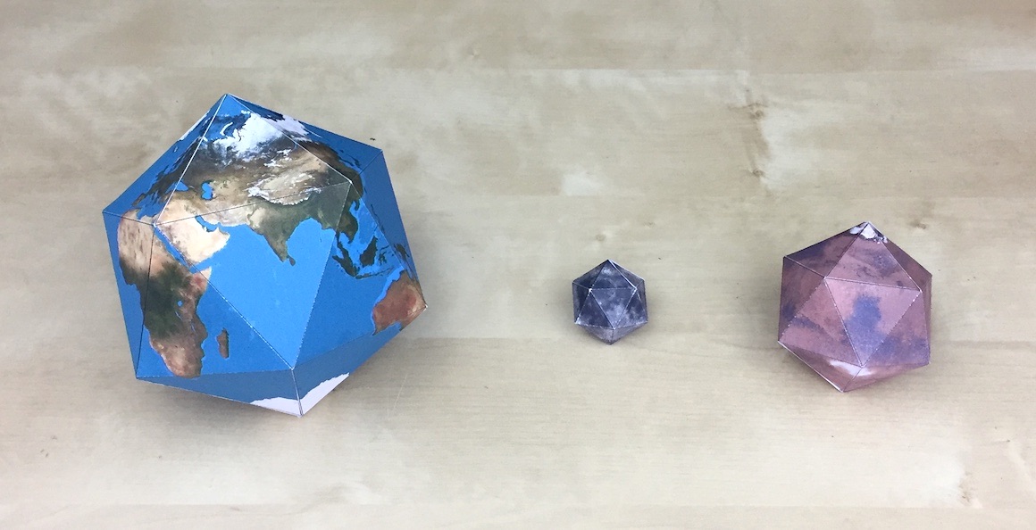 Folded icosahedral paper globes of the Earth, the Moon, and Mars, all to scale