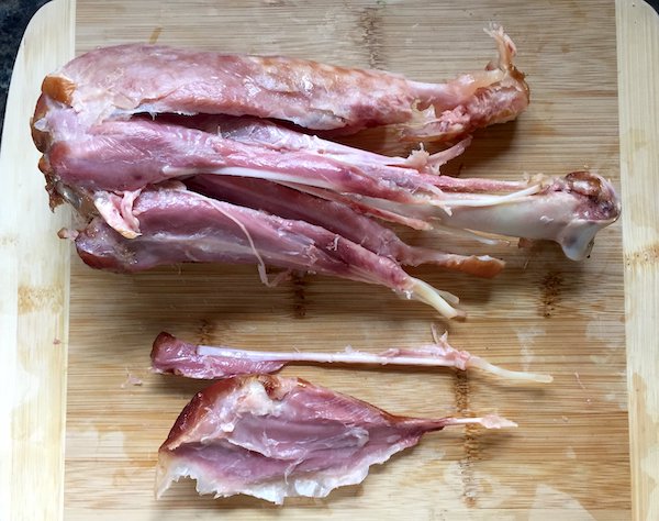 A smoked turkey drumstick with the muscles pried apart, revealing the arrangement of muscles and tendons